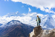 Hiker standing with backpack and enjoying a beautiful mountains from top of mountain.