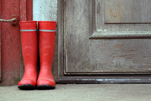 Red Wellies Outside Of Old House.