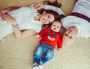 Wall Mural - The happinest mother,father  and  son lie on the bed