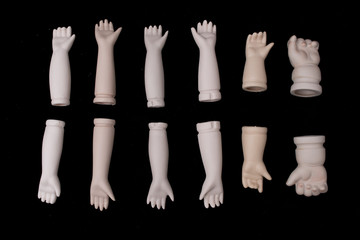 Broken Doll Body Parts Hands and Arms on Black Background