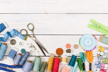 Tools And Accessories For Sewing On Light Wooden Background.
