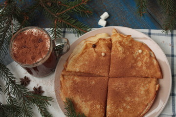 Wall Mural - Christmas hot cocoa with marshmallows and Russian pancakes. tree branches, cinnamon, and cookies on a napkin