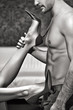 © sakkmesterke - Woman legs in high heels playing on man abs black and white