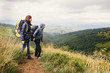 © ninelutsk - Couple of travelers with backpacks looking on the hills