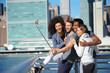 © goodluz - Group of friends taking selfie picture, Manhattan in background