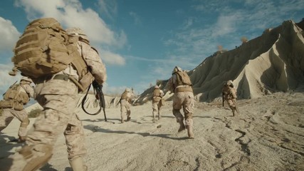 Wall Mural -  Follow Shot of Squad of Soldiers Running Forward During Military Operation in the Desert.  on RED EPIC Cinema Camera in 4K (UHD).