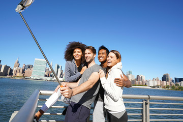 Wall Mural - Group of friends taking selfie picture, Manhattan in background