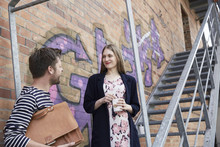 Smiling Man With Bag Looking At Woman On Stairs