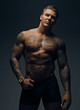 © Fxquadro - Portrait of tattooed muscular male in a shadow.