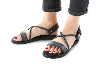 Sticker - Black leather sandals on woman's feet isolated on white