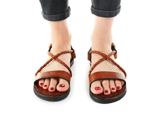 Sticker - Brown leather sandals on woman's feet isolated on white