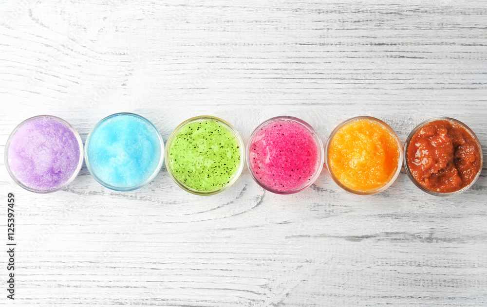Body scrubs on wooden background