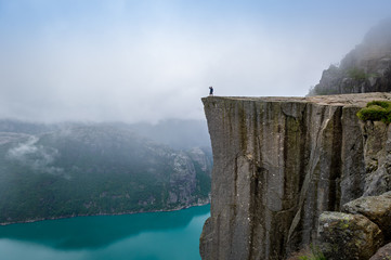 Tourist standing at Prekestolen rock's edge.