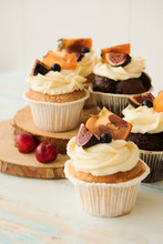 Cupcakes With Fig, Persimmon And Cream Cheese On A Wooden Table