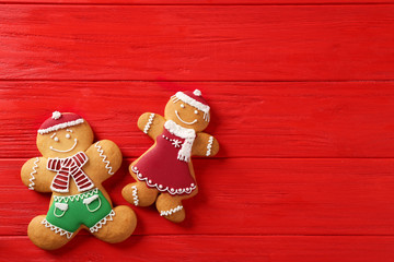 Wall Mural - Tasty gingerbread cookies on red wooden table