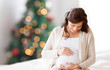 © Syda Productions - happy pregnant woman sitting on bed at christmas