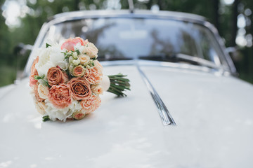 wedding bouquet on the hood of a white retro car