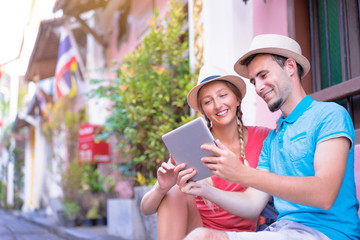 Wall Mural - Digital guide. Tourism and technology. Traveling couple of backpackers using digital tablet outdoor.