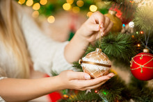 Closeup Of Woman Holding Golden Christmas Bauble