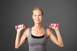 © sepy - Fitness. Portrait of an attractive blond woman working out with dumbbell weights, toning her biceps while standing against isolated background.