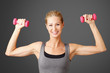 © sepy - Fitness. Portrait of an attractive blond woman working out with dumbbell weights, toning her biceps while standing against isolated background.