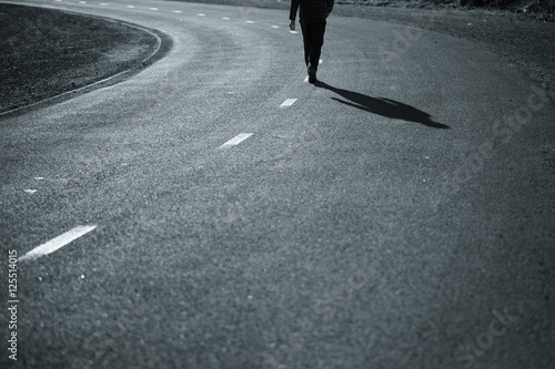 Lonely Man Walking In The Middle Of The Road At Sunny Day Black And White Color Pedestrian Shadows On Asphalt Road Selective Focus Used Buy This Stock Photo And Explore Similar