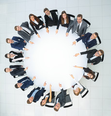 Poster - Top view of smilimg business team, sitting at a round table on w