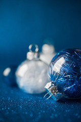 Wall Mural - white and blue christmas ornaments on dark blue glitter background with space for text. merry christ