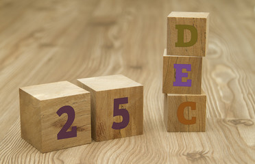 Cube shape calendar for December 25 on wooden surface.