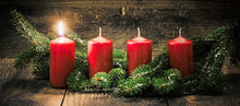 Ersterer Advent: Eine Leuchtende Kerze Vor Einem Holzhintergund