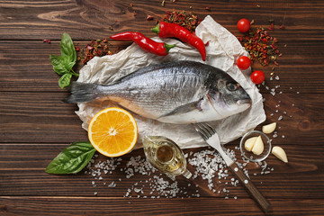 Wall Mural - Raw fish with spices on wooden table