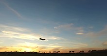 Silhouette Of A Military C-130 Airplane Is Approaching To The Airport At The Sunset.
