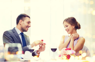 Poster - man proposing to his girlfriend at restaurant