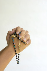 Wall Mural - Hands of a asian woman Praying with Rosary isolated background
