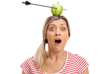 Wall Mural - Terrified young woman posing with apple pierced by an arrow