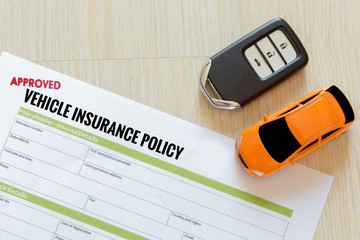 Wall Mural - Top view of Approved vehicle insurance policy with car key