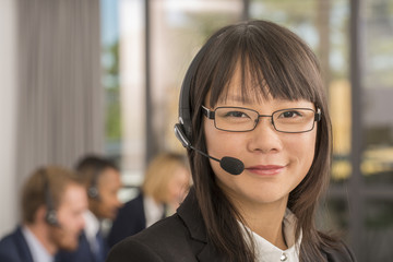 Portrait of young asian woman working in a call canter