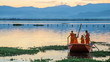 Novice monks row a boat in the lake,Phayao,Thailand