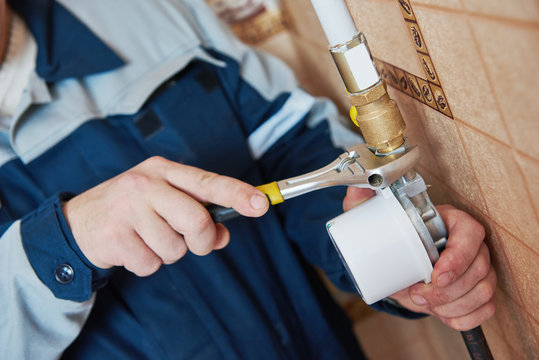 Plumber technician works with gas meter