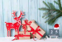 Christmas Decorations With Gift Boxes, Block Calendar And Deer, Wooden Background With Fir Branch