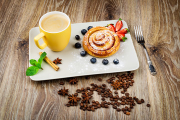 Wall Mural - Cup of coffee and pastry on wooden background