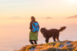 Woman with her black shepherd walking in the mountains