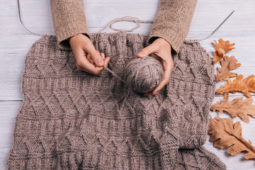 Wall Mural - Top view of a woman's hands holding a ball of wool yarn on a tab