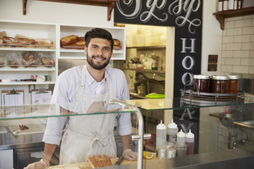 Wall Mural - Small business owner behind the counter of a sandwich bar