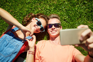 happy couple taking selfie on smartphone at summer