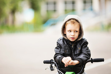 Wall Mural - portrait of adorable little urban boy wearing black leather jack