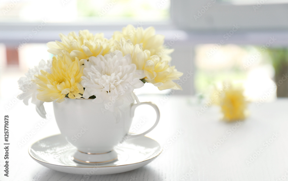 Bouquet of beautiful flowers in a cup on a  table