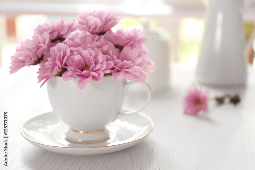 Bouquet of beautiful flowers in a cup on a  table