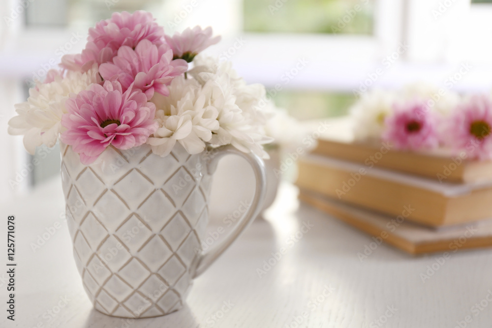 Bouquet of beautiful flowers in a cup on a  table