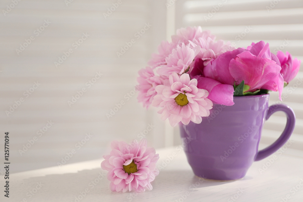 Bouquet of beautiful flowers in a cup on a  table